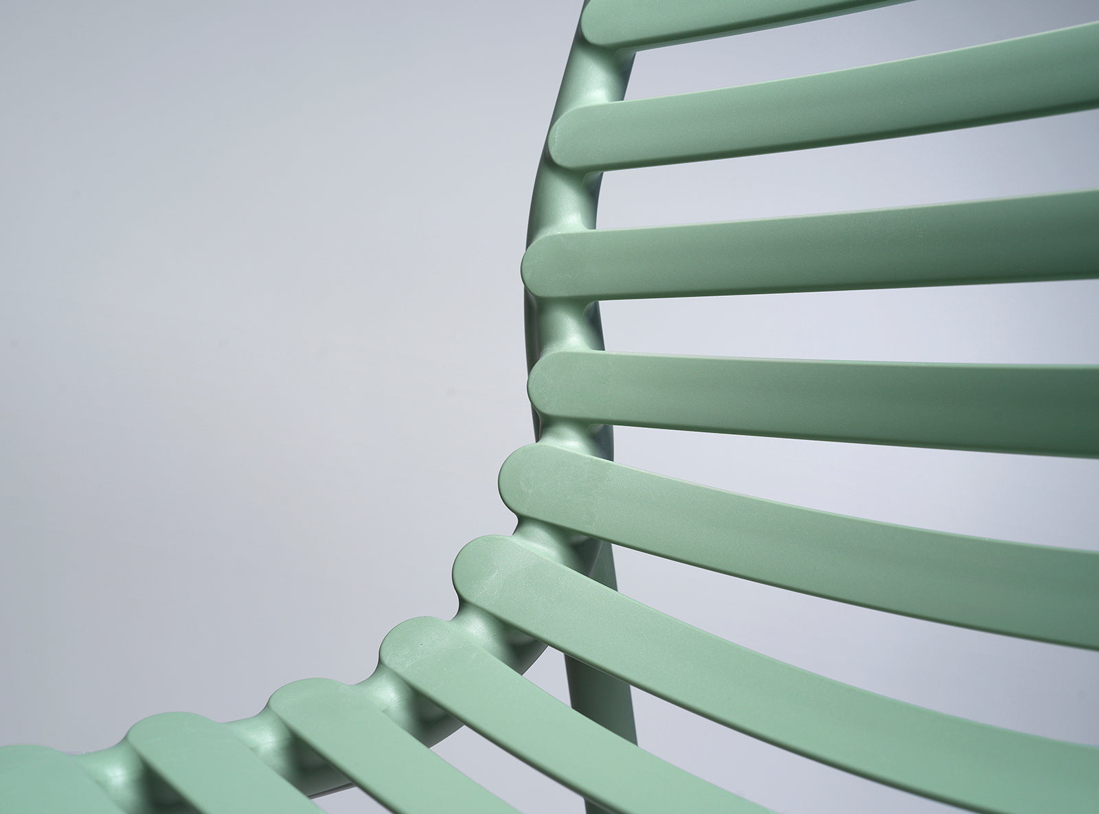 Close-up of a light green chair with a plain background