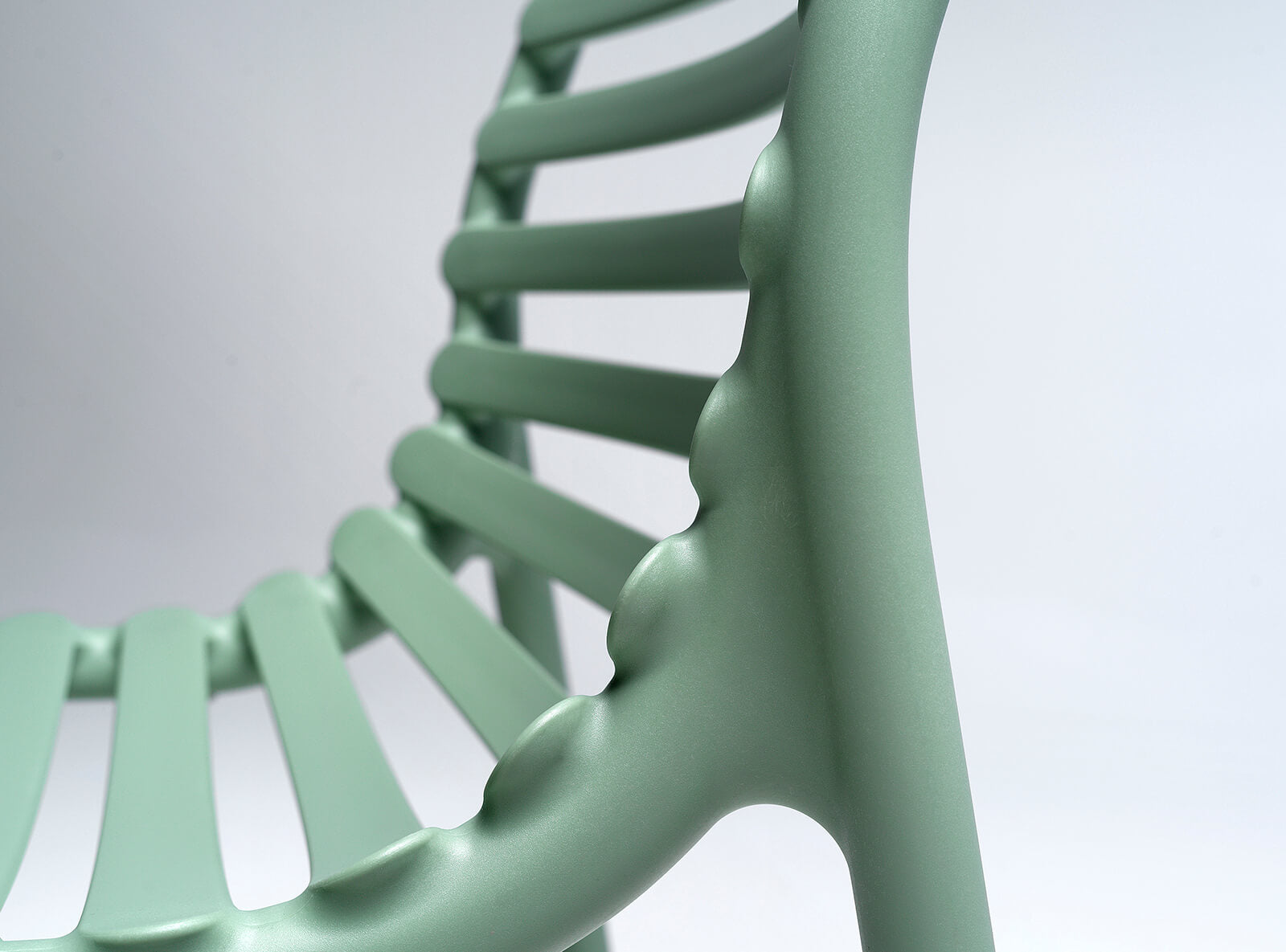 Close-up of a light green chair with a blurred background