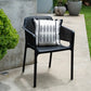 Black outdoor chair with a patterned cushion on a concrete patio.