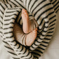 Baby feet peeking out from under a striped blanket