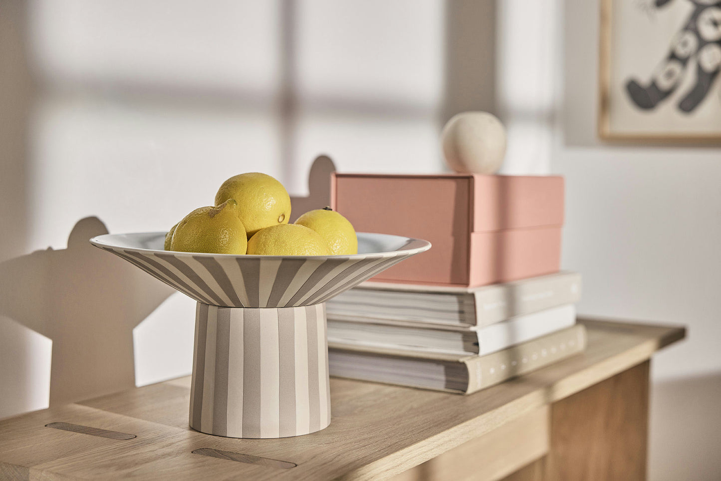 Striped bowl with lemons on a wooden surface