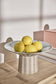 Striped ceramic pedestal with lemons on a wooden surface