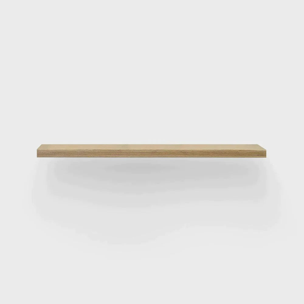 Floating oak shelf against a white wall