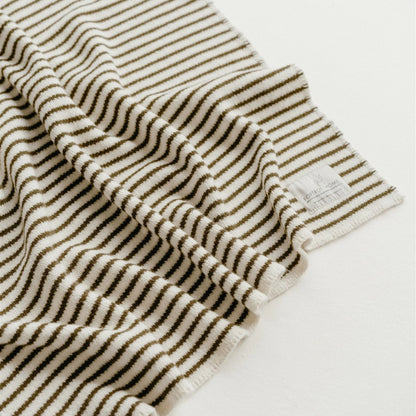 Close-up of a striped towel with a visible brand label on a white background