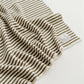 Close-up of a striped towel with a visible brand label on a white background