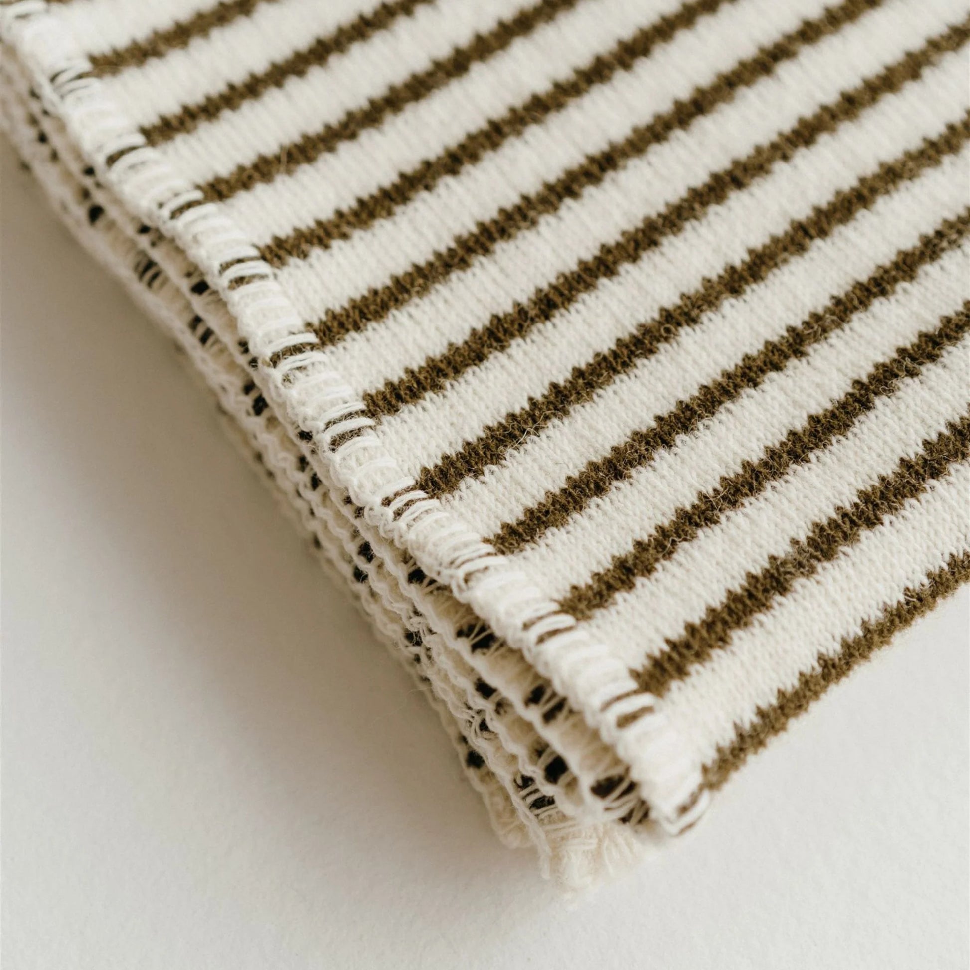 Folded fabric with brown and black striped pattern on a light background