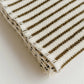 Folded fabric with brown and black striped pattern on a light background