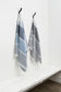 Two striped towels hanging on hooks against a white wall.