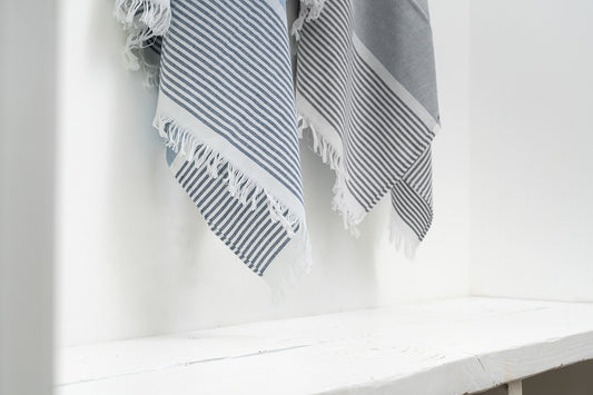 Striped towel with frayed edges on a white surface