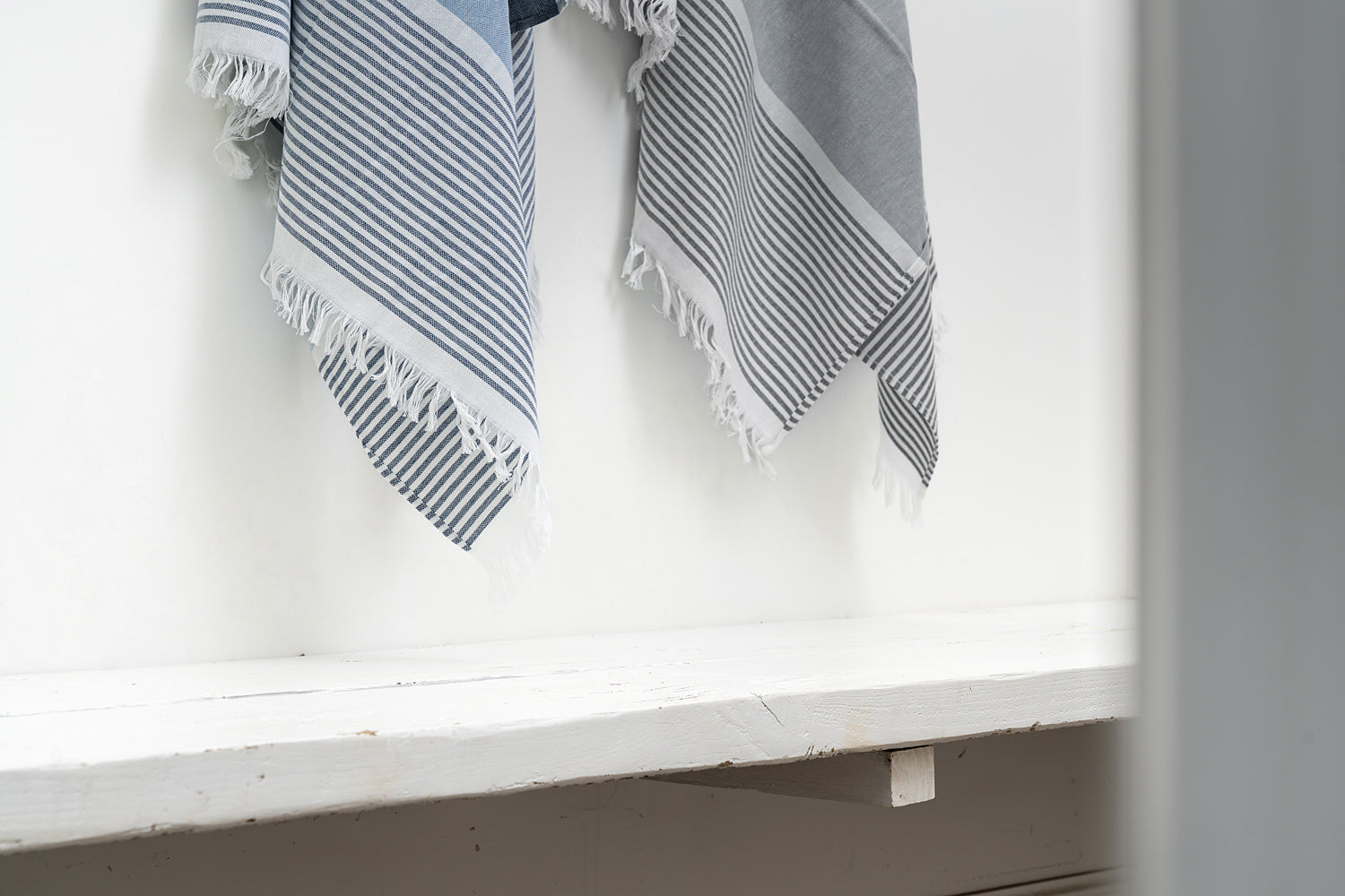 Striped towel hanging on a white shelf