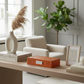 Modern living room with a beige armchair, wooden coffee table, and decorative items.