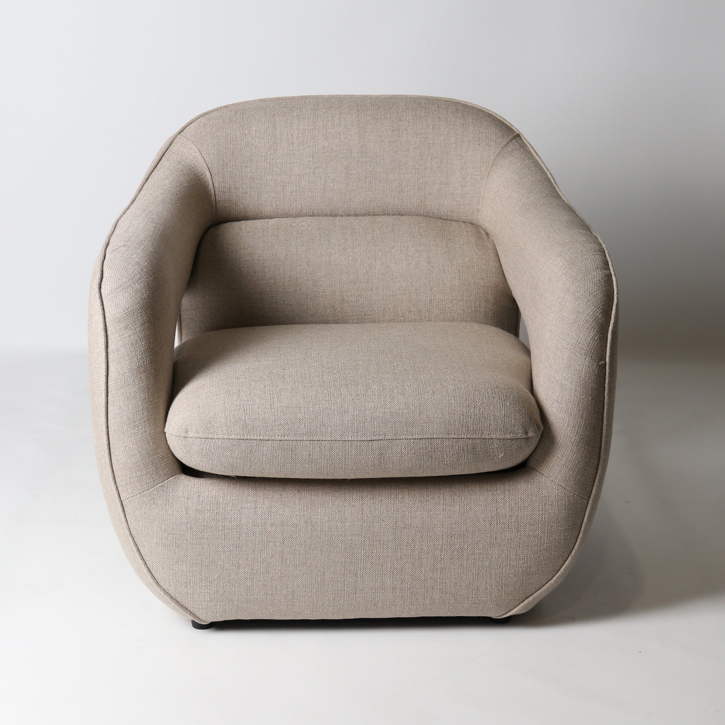 Architectural rounded open sided lounge chair in neutral fabric