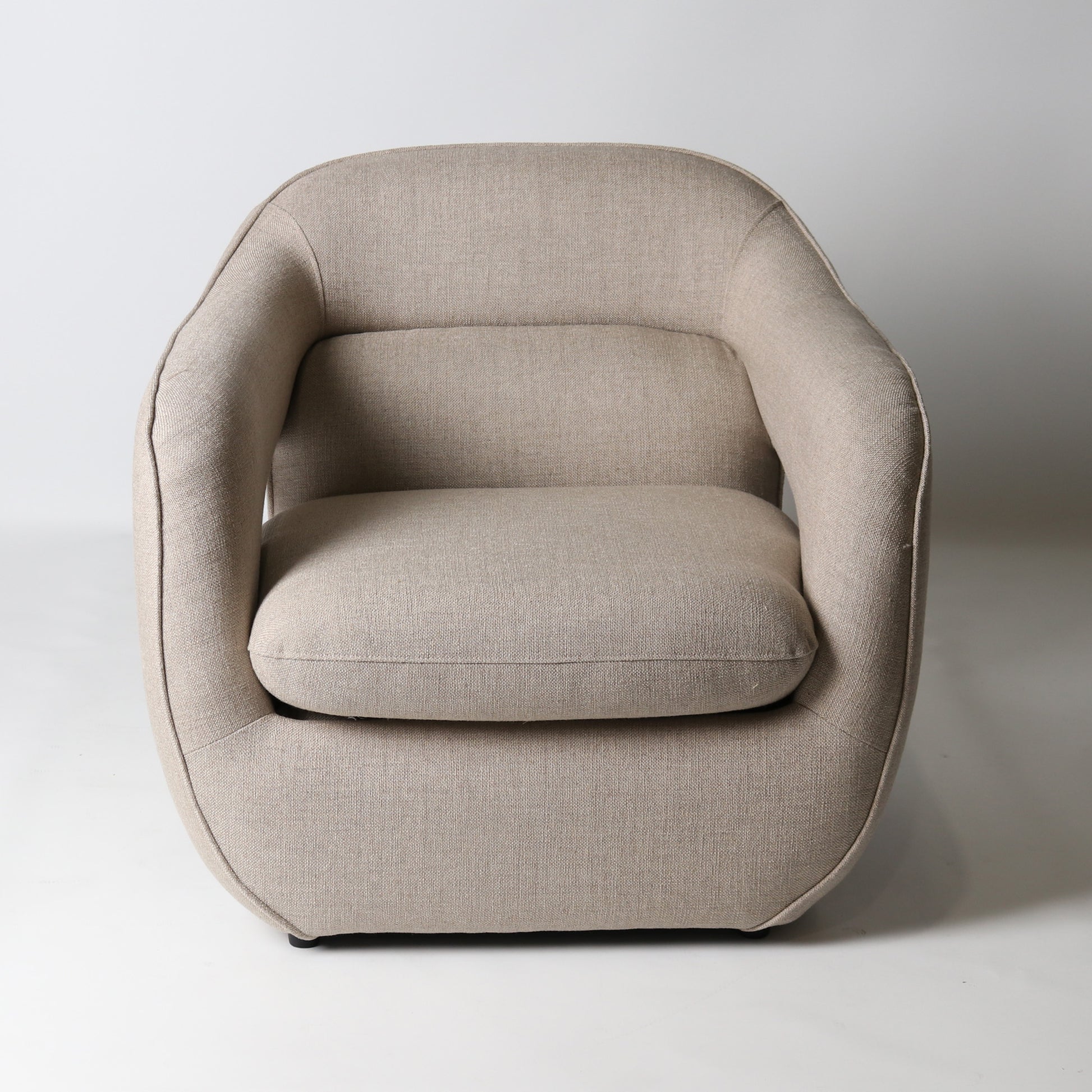 Architectural rounded open sided lounge chair in neutral fabric