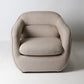 Architectural rounded open sided lounge chair in neutral fabric