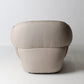 Architectural rounded open sided lounge chair in neutral fabric - back view