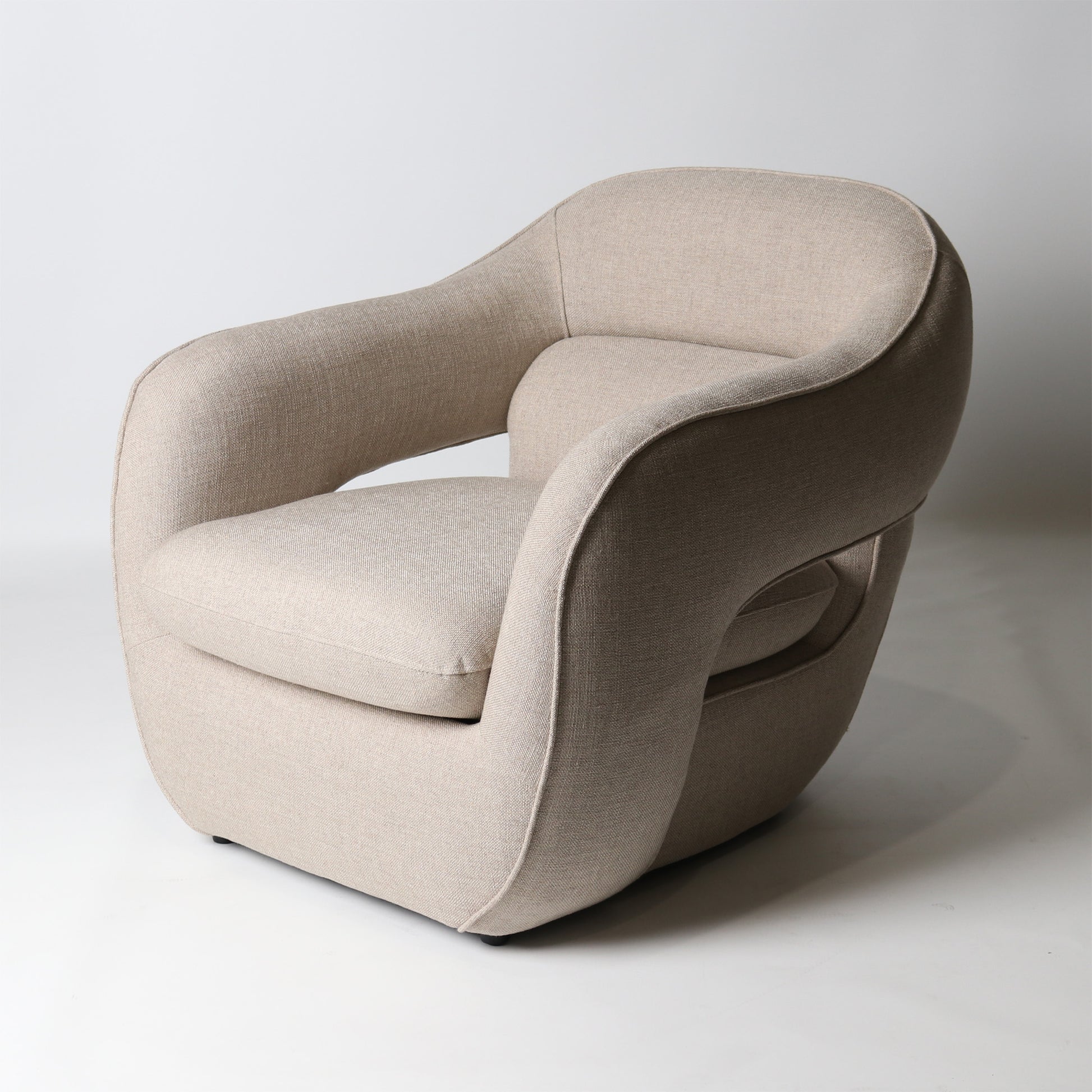 Architectural rounded open sided lounge chair in neutral fabric