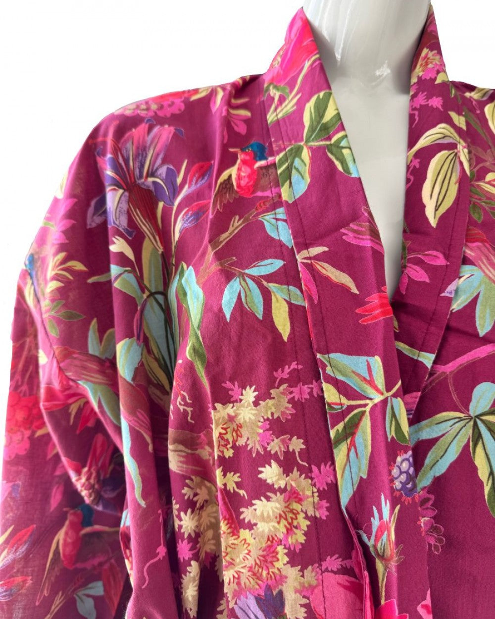 Mannequin wearing a vibrant floral-patterned garment with a magenta background