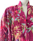 Mannequin wearing a vibrant floral-patterned garment with a magenta background