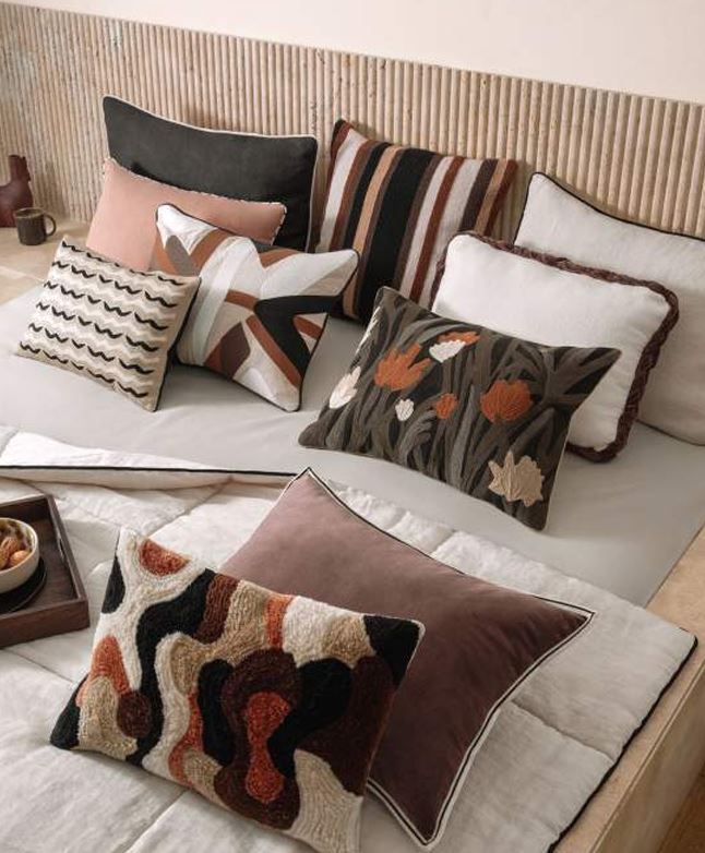 Decorative pillows on a bed with a neutral color scheme