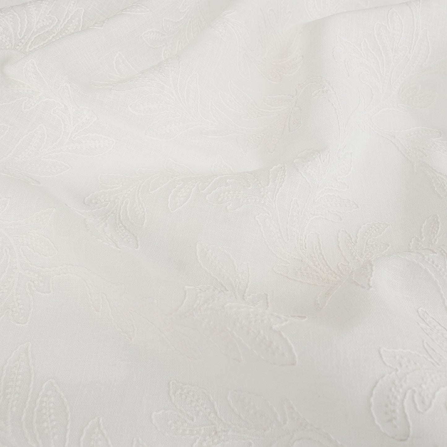 white embroidered drapery fabric wthi leaf pattern