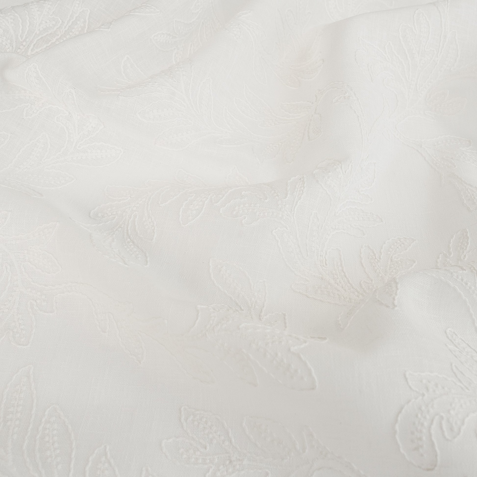 white embroidered drapery fabric wthi leaf pattern
