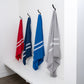 Four colorful towels hanging on hooks against a white wall.