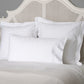 White pillows on a bed with a textured headboard