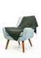 A light blue upholstered armchair with wooden legs, draped with a dark olive green textured throw blanket, photographed on a clean white background.
