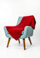Light blue armchair with a red blanket draped over it on a white background