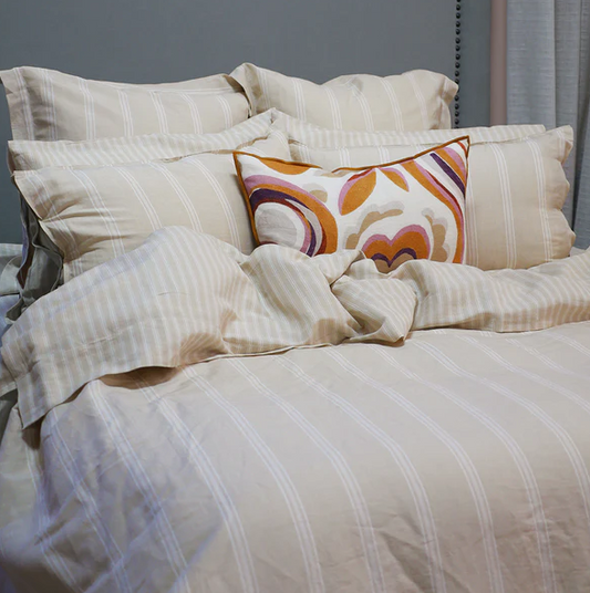 Luxurious bed with striped linen in cream and white