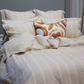 Luxurious bed with striped linen in cream and white