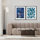 Two abstract maori artworks on a wall above a sofa in a living room.