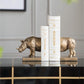 Decorative bookends shaped like rhinos on a shelf with a neutral background