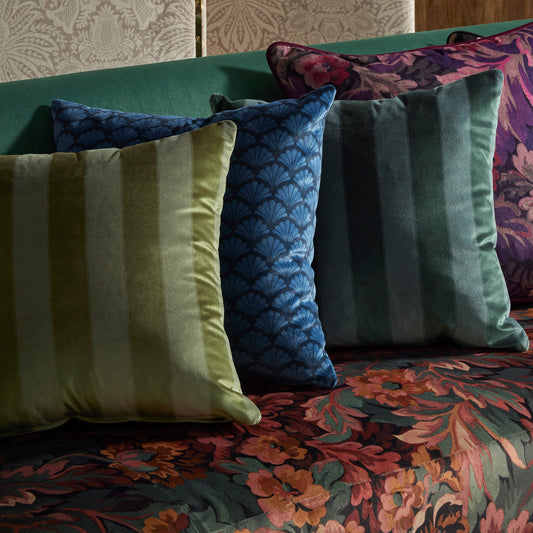 Riviera striped velvet cushions part of the borchelli collection in a rown in greens blues and plums on a floral sofa