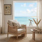 Cozy living room with a wicker chair, small table, and scenic window view of the ocean.