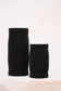 Two black ribbed vases on a light beige background