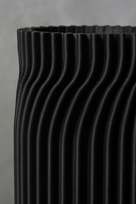 Black 3d printed vase on a gray background