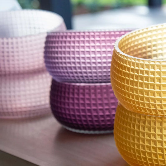 3 stacks of textured checkered glass bowls in yellow, purple and pink