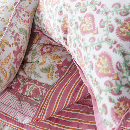Close-up of floral and striped fabric patterns in pink, green, and orange.
