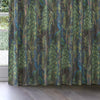 Curtain with peacock feather pattern in a room with a window.