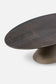 Dark brown oval table with a textured surface on a white background