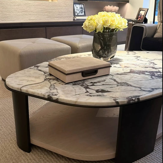 Marble coffee table with a vase of yellow roses in a living room setting