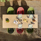 Top-down view of a dining table with plates, cups, and food on a wooden deck.