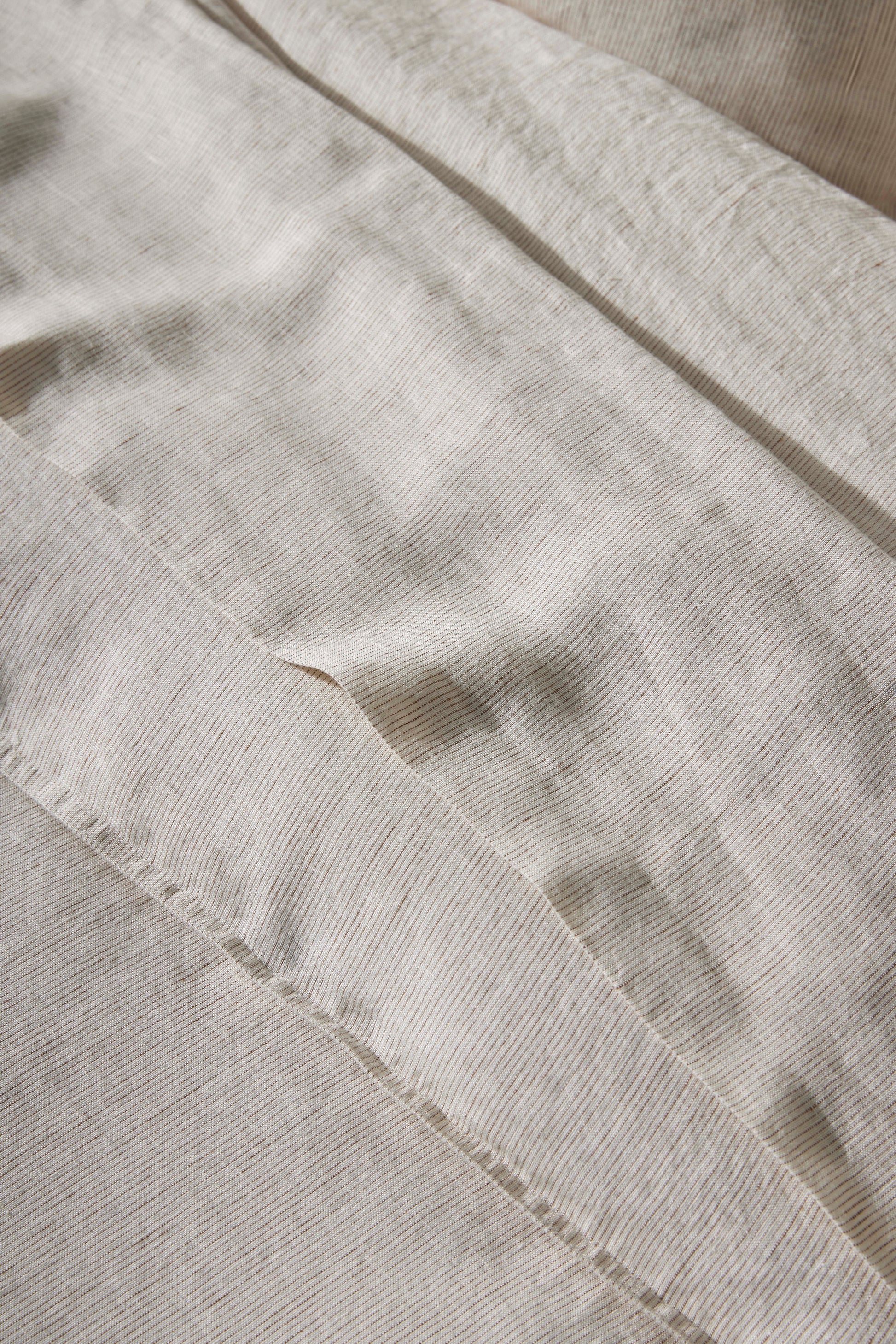 Close-up of beige Sova bed linen with a subtle pattern