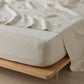 Beige bedding on a wooden bed frame