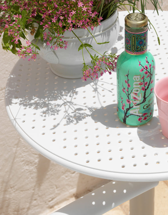 Arizona bottle with cherry blossom design on a white table outdoors