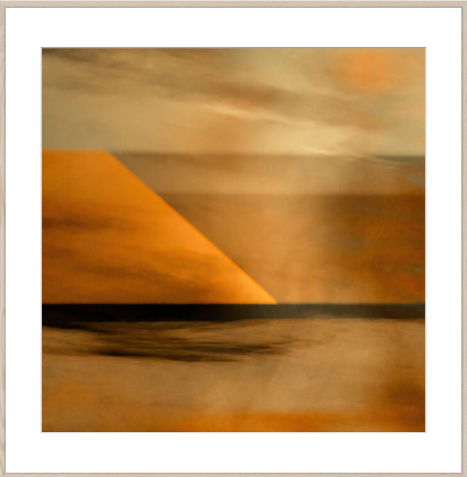 An abstract landscape art print featuring a warm orange geometric shape against a textured beige and brown background, presented with a white border and light wood frame.