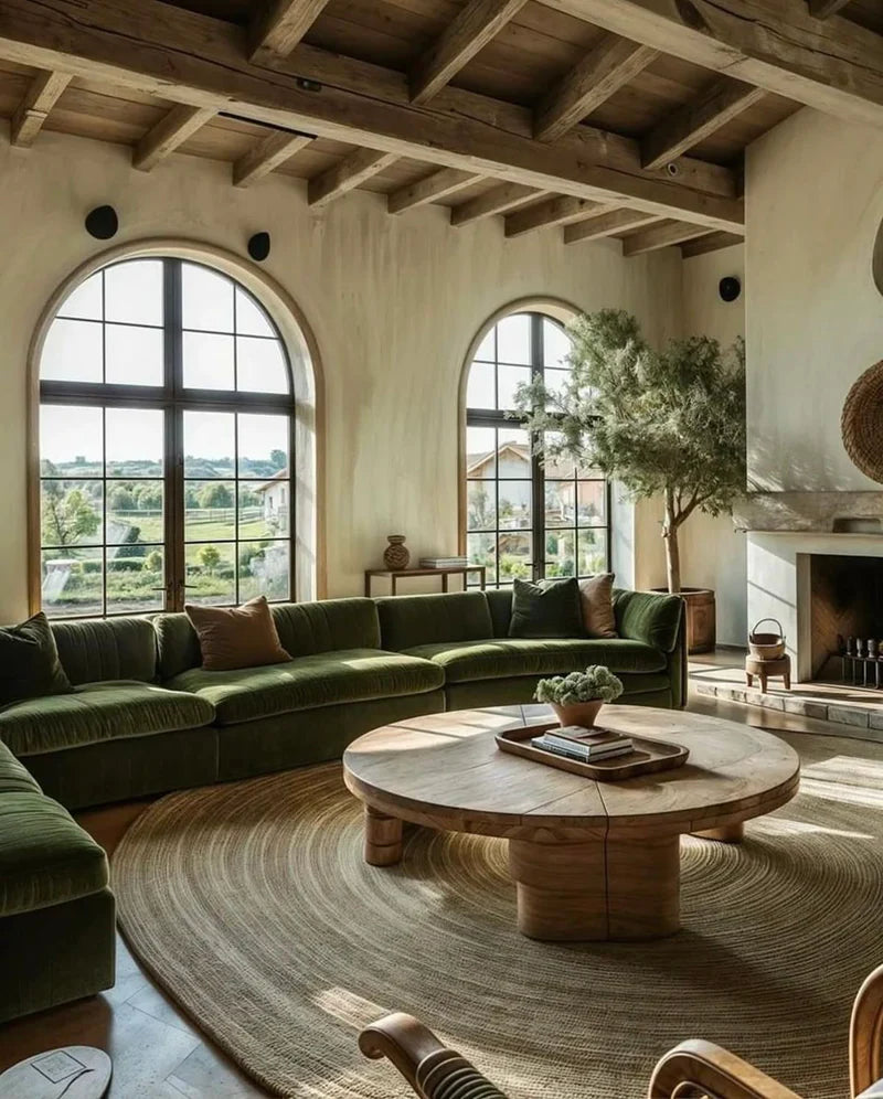 Cozy living room with green sectional sofa, wooden coffee table, and large windows.