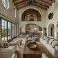 Luxurious living room with high ceilings, large windows, and a wooden coffee table.