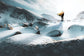 Person with a surfboard standing on a snowy landscape